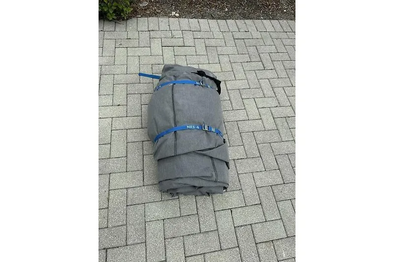  Yacht Photos Pics Rolled-up boat cover for 2022 Edgewater 262CC on paved surface.