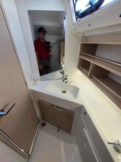 "makai" Yacht Photos Pics Interior of 2020 Beneteau Oceanis 30.1 yacht bathroom with sink and mirror.