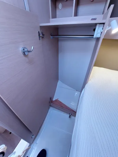 "makai" Yacht Photos Pics Beneteau Oceanis 30.1 2020 yacht interior closet with wooden finish and hanging rod.