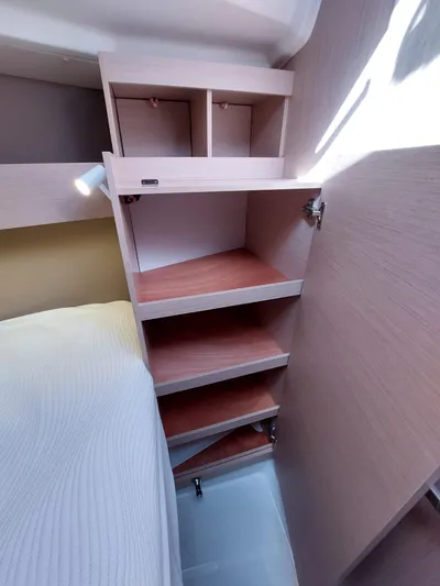 "makai" Yacht Photos Pics Interior shelving in 2020 Beneteau Oceanis 30.1 yacht cabin, featuring wooden shelves and storage.