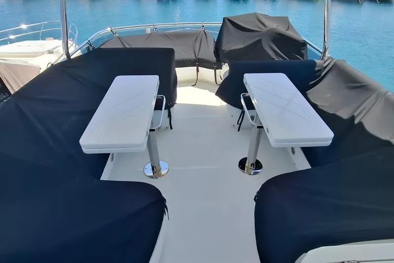  Yacht Photos Pics Flybridge of 2024 Galeon 560 Fly yacht with seating and tables, overlooking blue water.