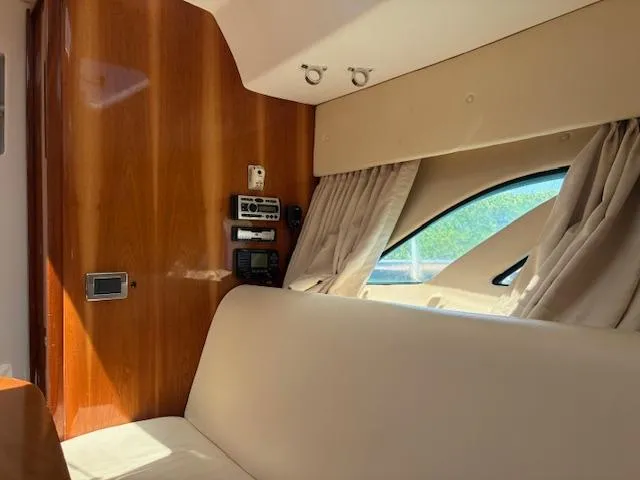  Yacht Photos Pics Interior of 2009 Intrepid 475 Sport Yacht with wood paneling and beige seating.