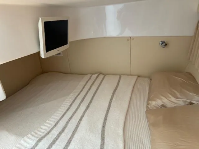  Yacht Photos Pics Cozy cabin interior of 2009 Intrepid 475 Sport Yacht with bed and wall-mounted TV.