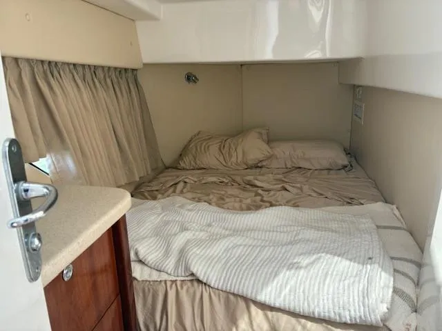  Yacht Photos Pics Cozy cabin interior of 2009 Intrepid 475 Sport Yacht with beige bedding and wooden accents.