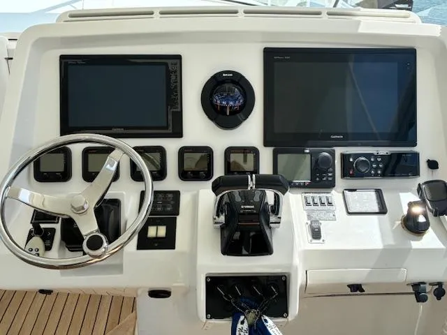  Yacht Photos Pics Control panel of a 2009 Intrepid 475 Sport Yacht with steering wheel and navigation screens.
