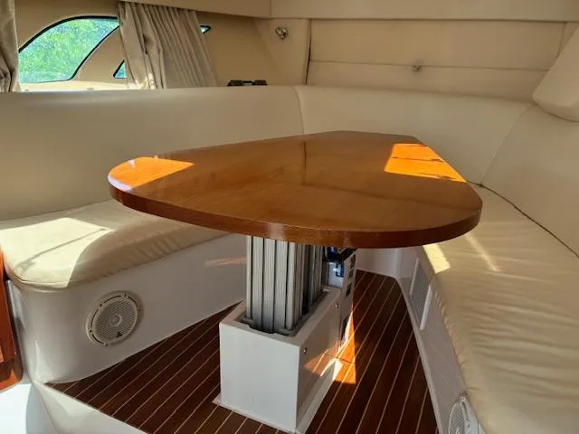  Yacht Photos Pics Interior of 2009 Intrepid 475 Sport Yacht with wooden table and cushioned seating.