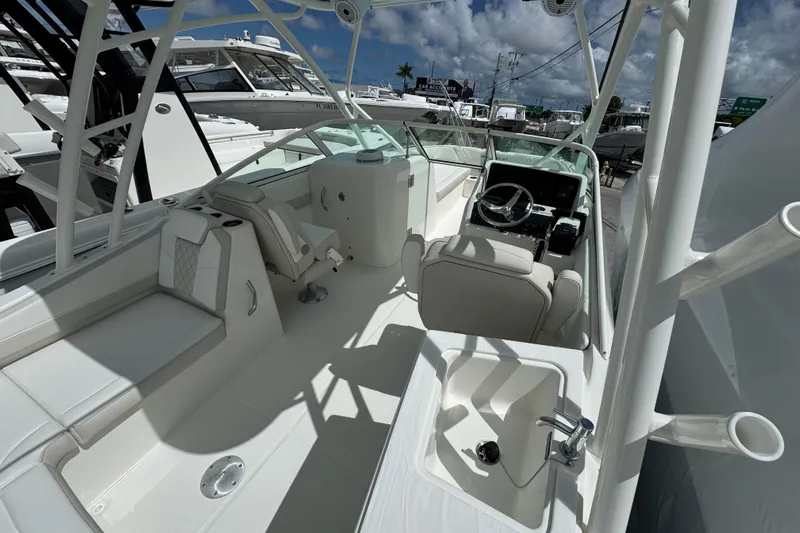 57582 230sd Sf Yacht Photos Pics 2026 World Cat 230 SD boat interior with helm, seating, and sink under a blue sky.
