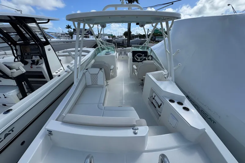57582 230sd Sf Yacht Photos Pics 2026 World Cat 230 SD boat interior with seating and steering wheel, docked under blue sky.