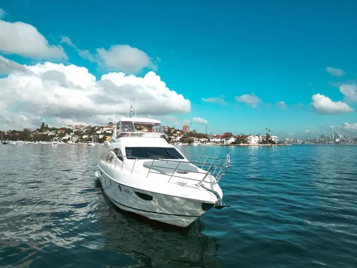 Azimut 62 Evolution Yacht Photos Pics 2007 Azimut 62 Evolution yacht cruising on a sunny day with cityscape in background.