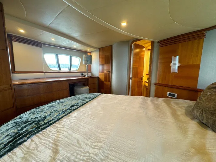 Azimut 62 Evolution Yacht Photos Pics Luxurious bedroom interior of 2007 Azimut 62 Evolution yacht with wood accents and large window.