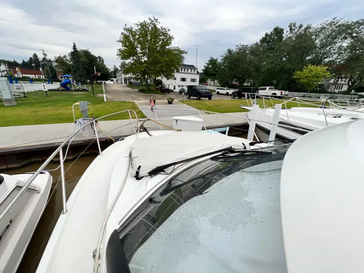  Yacht Photos Pics 2017 Jeanneau NC11 docked near a park with playground and parked vehicles.