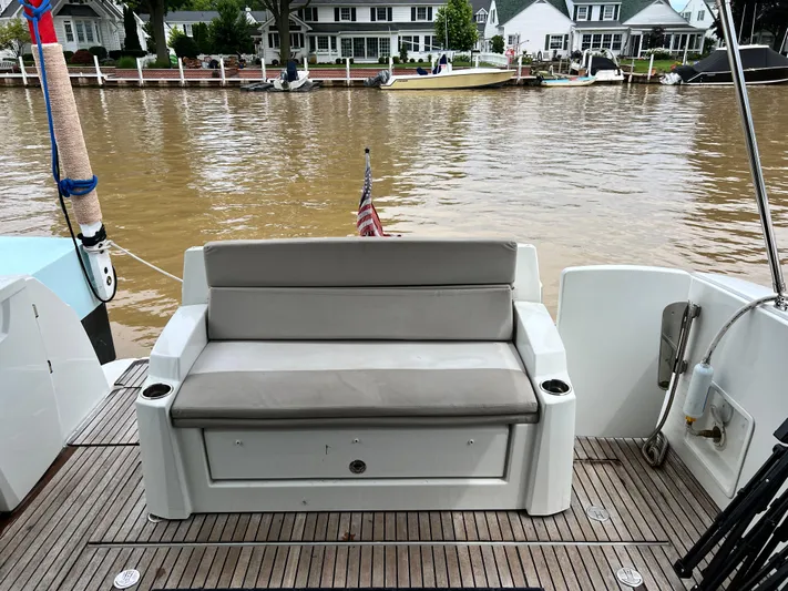  Yacht Photos Pics 2017 Jeanneau NC11 boat with rear seating, docked by waterfront homes.