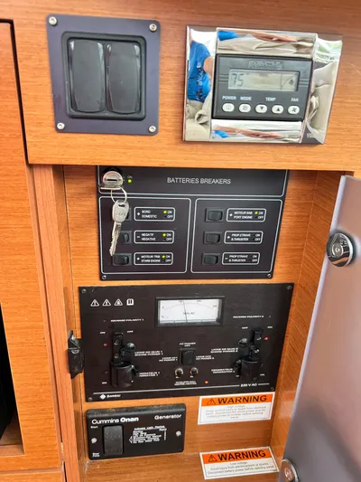  Yacht Photos Pics Electrical control panel on a 2017 Jeanneau NC11 boat, featuring battery breakers and generator controls.