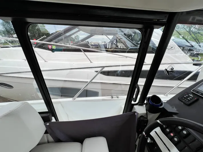  Yacht Photos Pics Interior view of 2017 Jeanneau NC11 boat cockpit with window and control panel.