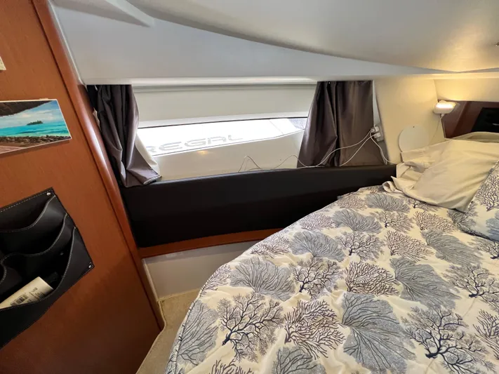  Yacht Photos Pics Cozy cabin interior of 2017 Jeanneau NC11 with patterned bedding and window view.