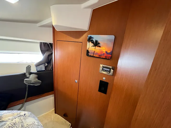  Yacht Photos Pics Interior of 2017 Jeanneau NC11 boat with wood paneling and sunset artwork.