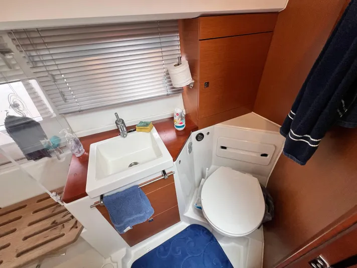  Yacht Photos Pics 2017 Jeanneau NC11 bathroom with sink, toilet, and wooden cabinetry.