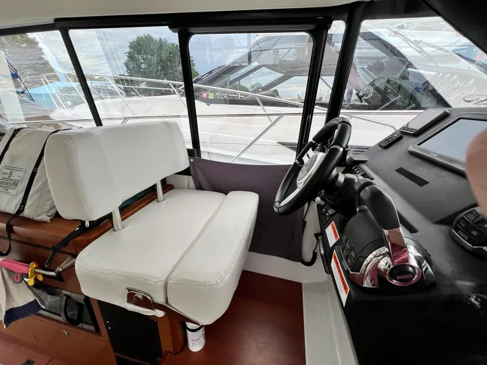  Yacht Photos Pics Interior of 2017 Jeanneau NC11 boat showing helm station and seating area.
