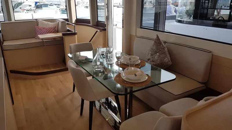  Yacht Photos Pics Luxurious interior of 2018 Sirena 64 yacht with elegant dining area and large windows.