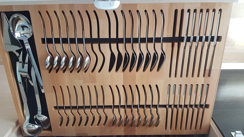  Yacht Photos Pics Organized cutlery drawer with spoons, forks, and knives in a wooden holder.