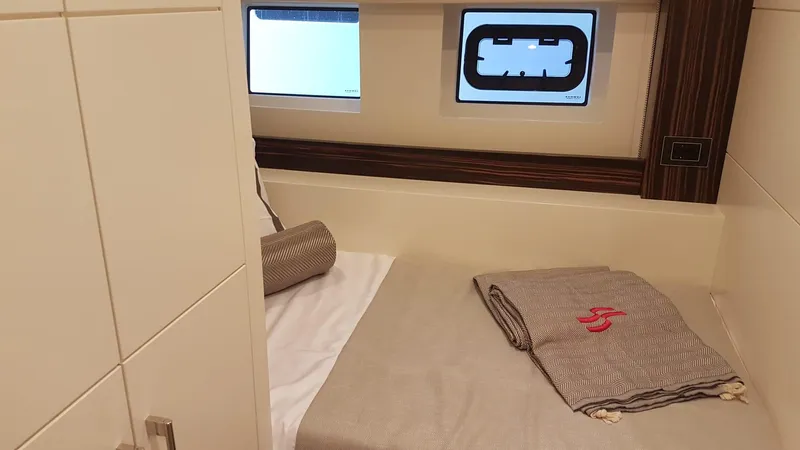  Yacht Photos Pics Cozy cabin interior of 2018 Sirena 64 yacht with bed and window view.