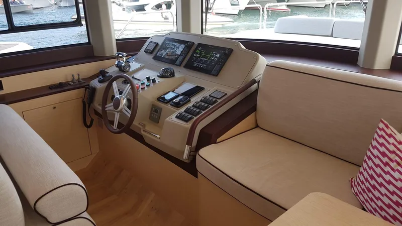  Yacht Photos Pics Helm station of 2018 Sirena 64 yacht with modern controls and beige seating.