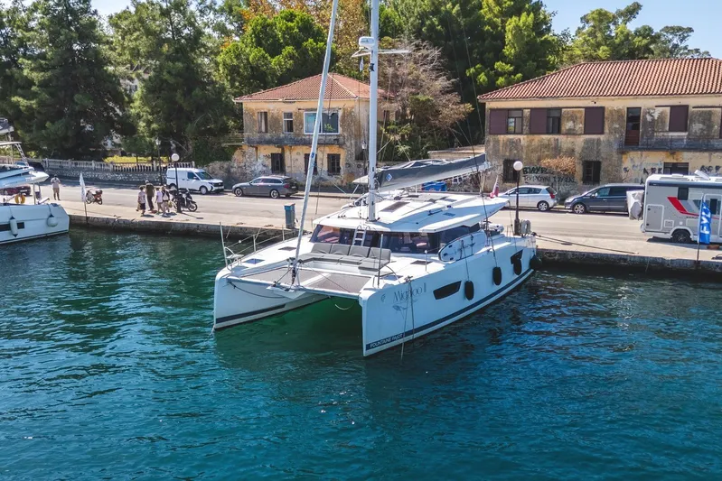  Yacht Photos Pics 2023 Fountaine Pajot Astrea 42 Maestro catamaran docked by a scenic waterfront.