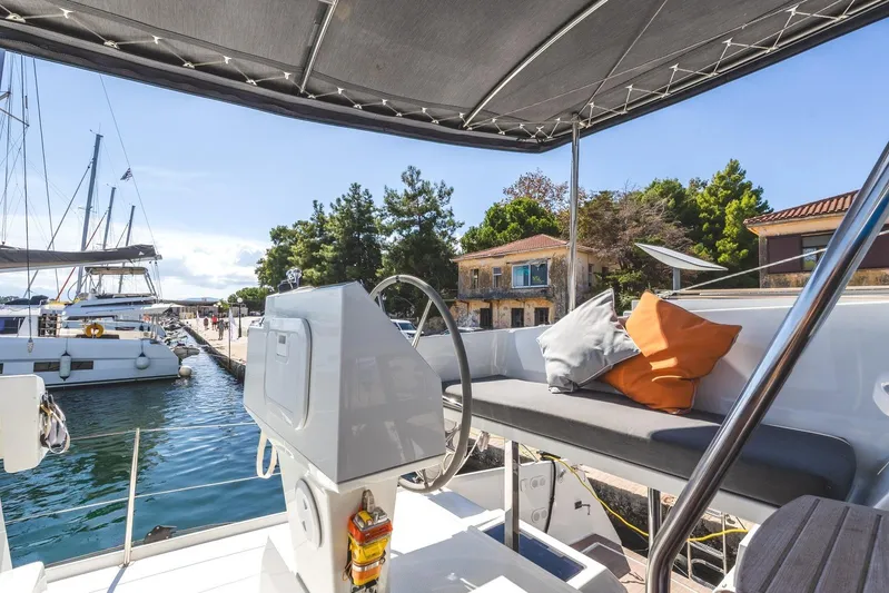  Yacht Photos Pics 2023 Fountaine Pajot Astrea 42 Maestro yacht docked, featuring helm and seating area.