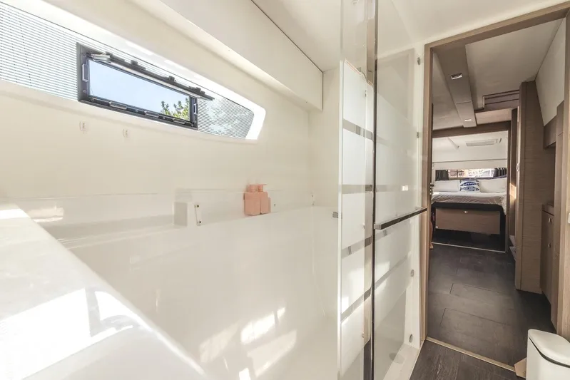  Yacht Photos Pics Luxurious interior of 2023 Fountaine Pajot Astrea 42 Maestro yacht, featuring modern bathroom and bedroom.