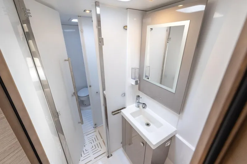  Yacht Photos Pics Modern bathroom in 2023 Fountaine Pajot Astrea 42 Maestro yacht, featuring sleek sink and mirror.