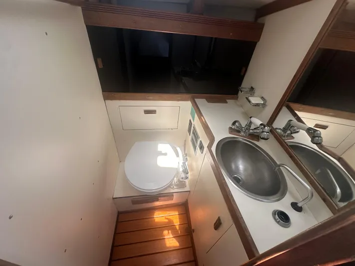 Hawk Yacht Photos Pics 1987 Sabre 42 yacht bathroom with sink, toilet, and wooden flooring.