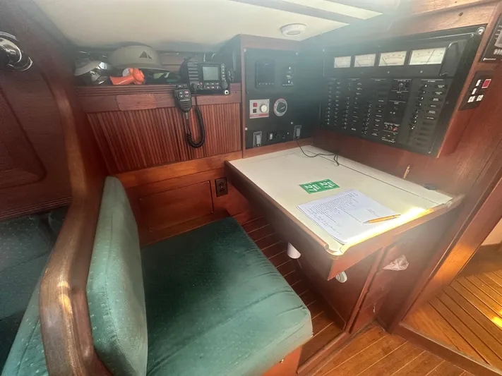 Hawk Yacht Photos Pics Navigation station in a 1987 Sabre 42 sailboat with control panels and seating.