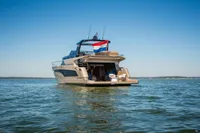 2025 Super Lauwersmeer SLX54 yacht on open water with a flag, clear sky.