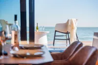 Luxurious Super Lauwersmeer SLX54 yacht interior with ocean view, wine, and elegant dining setup.