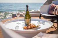 Luxurious Super Lauwersmeer SLX54 yacht deck with champagne, seafood, and ocean view.
