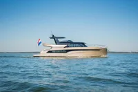 2025 Super Lauwersmeer SLX54 yacht cruising on open water under clear blue sky.