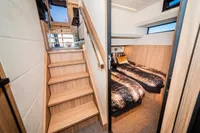 Interior of 2025 Super Lauwersmeer SLX54 yacht with twin beds and wooden stairs.