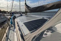 1984 Island Trader 40 sailboat with solar panel, docked under a partly cloudy sky.