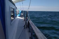 Sailing on a 1984 Island Trader 40 yacht, open sea view, clear blue sky.
