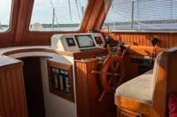 1984 Island Trader 40 boat interior with wooden helm, navigation instruments, and cozy seating.