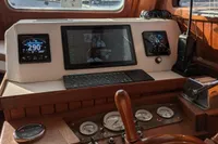 Interior helm of 1984 Island Trader 40 sailboat with navigation instruments and wooden steering wheel.
