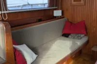 Cozy interior of 1984 Island Trader 40 sailboat with wooden paneling and cushioned seating.
