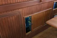 Wood-paneled interior of 1984 Island Trader 40 boat with open storage compartments.