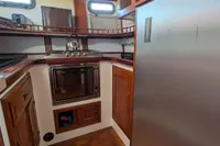 1984 Island Trader 40 yacht kitchen with wood cabinetry and stainless steel appliances.