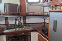 1984 Island Trader 40 yacht kitchen with stove, oven, and wooden cabinetry.