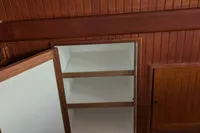 Open wooden cabinet with shelves on 1984 Island Trader 40 boat interior.