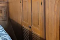Wooden interior of 1984 Island Trader 40 sailboat with louvered cabinet doors.