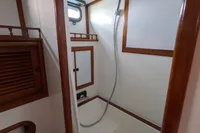 1984 Island Trader 40 yacht bathroom with shower, wooden accents, and nautical design.