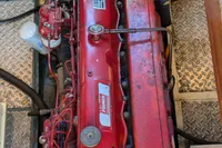Red engine of a 1984 Island Trader 40 boat, featuring detailed components and metal flooring.