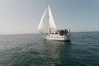 1984 Island Trader 40 sailboat cruising on open sea under clear skies.